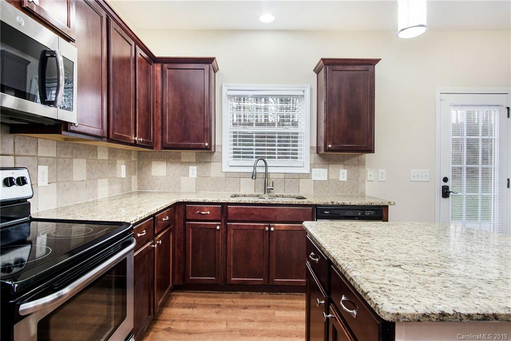 3727 Burnage Hall Road Harrisburg, NC 28075 - Photo 2 of 21 a kitchen with granite countertop stainless steel appliances and wooden cabinets