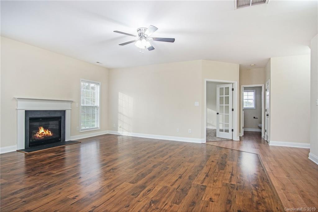 3727 Burnage Hall Road Harrisburg, NC 28075 - Photo 3 of 21 a view of an empty room with wooden floor fireplace and a window