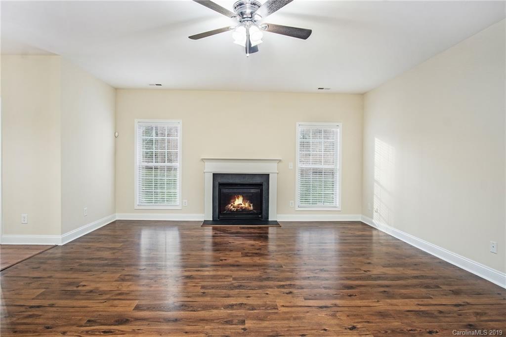 3727 Burnage Hall Road Harrisburg, NC 28075 - Photo 8 of 21 a view of an empty room with wooden floor fireplace and a window