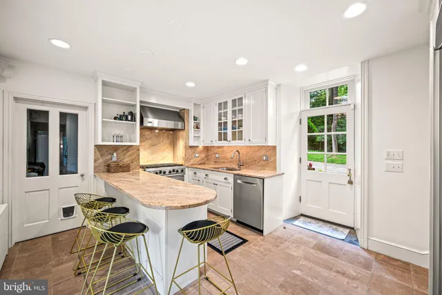 a kitchen with a dining table chairs and refrigerator