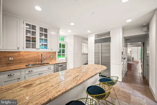 a large kitchen with kitchen island stainless steel appliances and view of living room