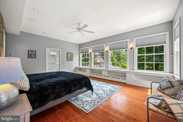 a spacious bedroom with a bed a couch and large window