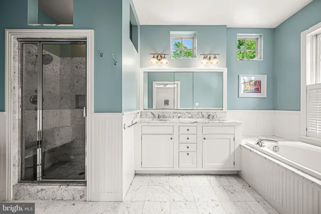 a bathroom with a tub a sink and a mirror