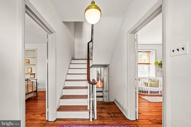 a view of a hallway with wooden floor and entryway