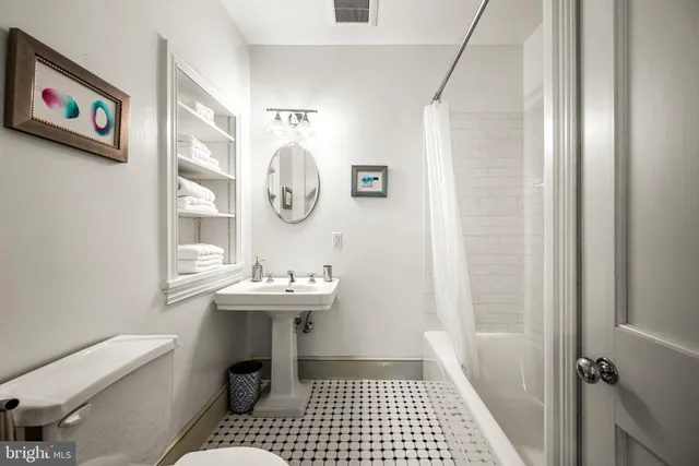 a bathroom with a sink a toilet and a window