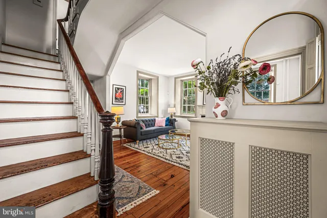 a living room with furniture flowerpot and wooden floor