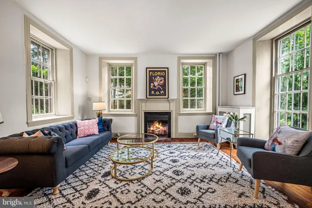 a living room with furniture a large window and a fireplace
