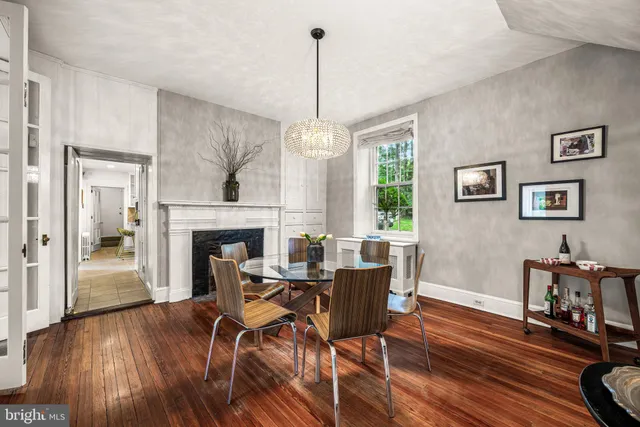 a view of a livingroom with furniture a fireplace wooden floor and a chandelier