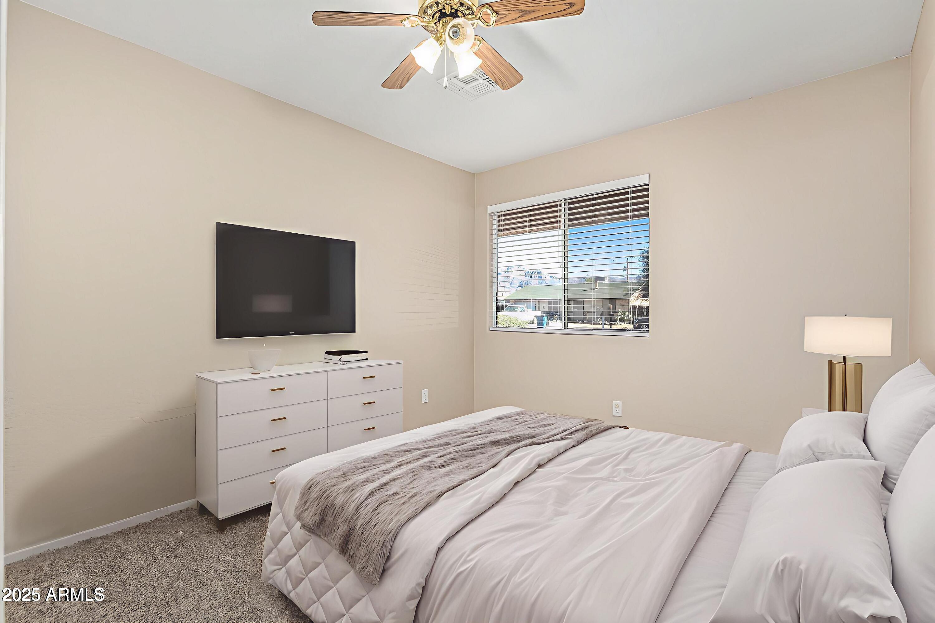 2264 South Belair Road Apache Junction, AZ 85119 - Photo 12 of 19 a bedroom with a large bed and a flat screen tv