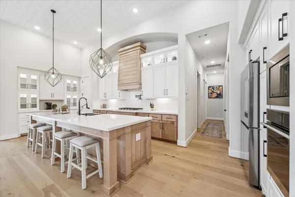 a open kitchen with stainless steel appliances granite countertop a sink a stove and a refrigerator