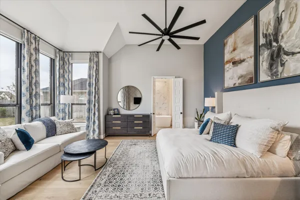 a large bedroom with a bed and wooden floor