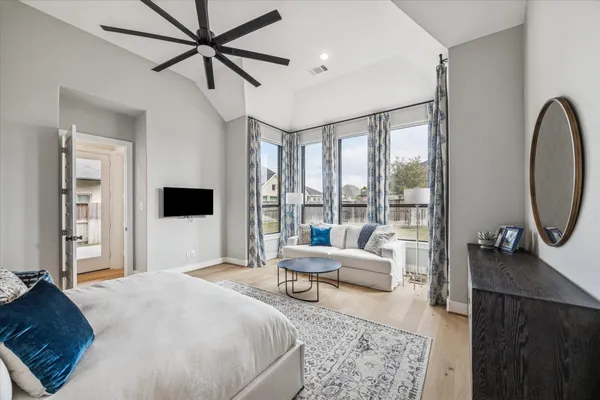 a spacious bedroom with a bed a dresser and potted plant