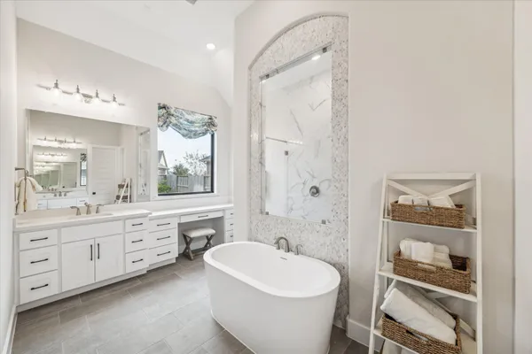 a spacious bathroom with a bathtub sink and mirror