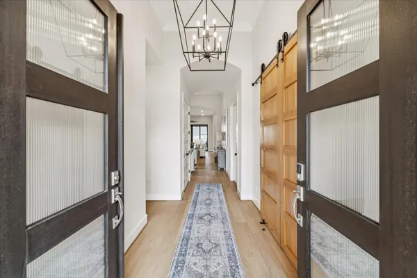 a view of a hallway with a livingroom and furniture