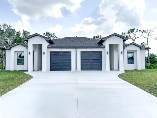 front view of a house with a yard and garage
