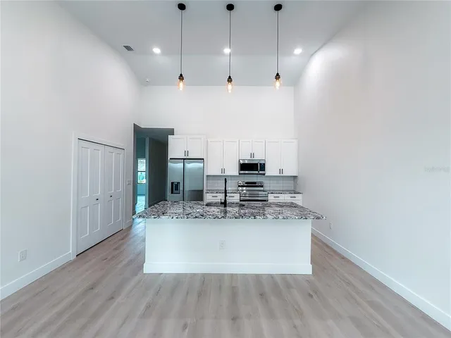 a large white kitchen with a large island oven