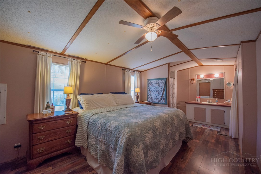 1848 West Mill Creek Road Warrensville, NC 28693 - Photo 27 of 50 a bedroom with a bed and a chandelier