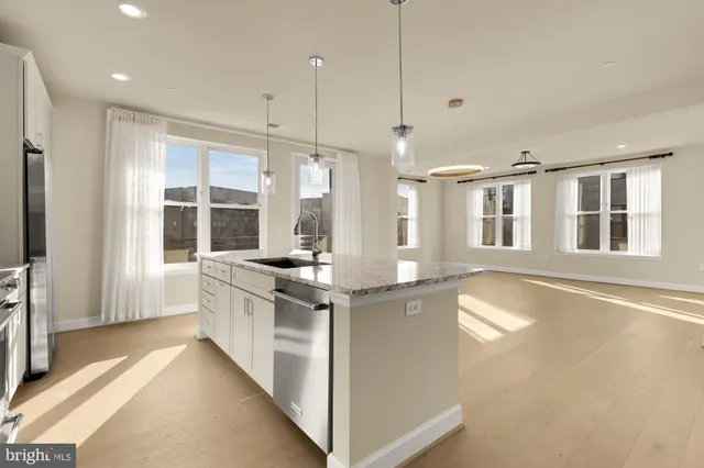 a kitchen with stainless steel appliances granite countertop a stove and a large window