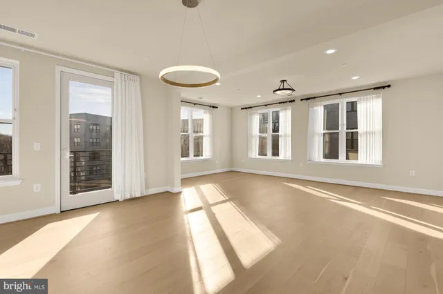 a view of an empty room with glass door and windows