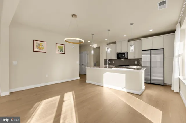 a view of kitchen with kitchen island and stainless steel appliances