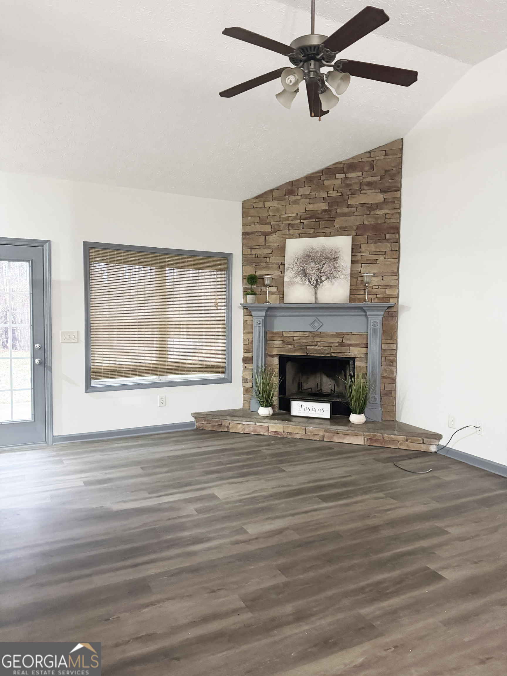 314 Hickory Road Jackson, GA 30233 - Photo 3 of 23 a view of an empty room with wooden floor fireplace and a window