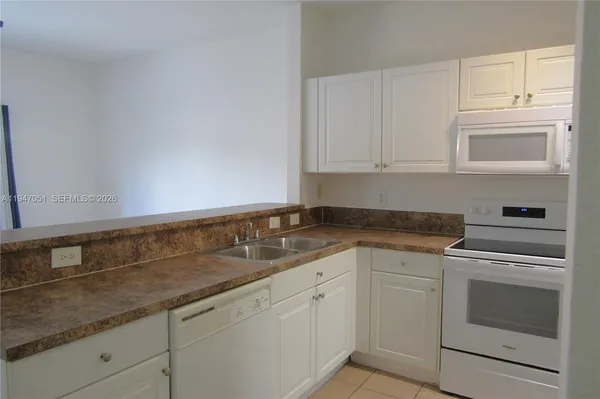 a bathroom with a granite countertop sink a mirror and a bathtub