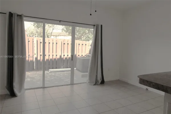 a room with a white cabinet and a chandelier fan