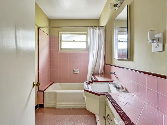 a bathroom with a tub sink and mirror