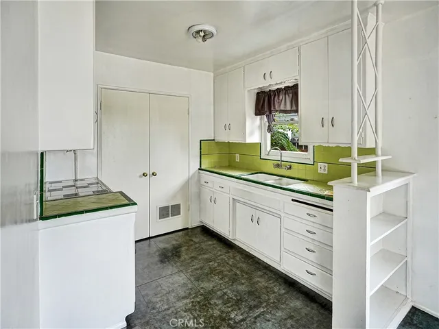 a kitchen with white cabinets and white appliances