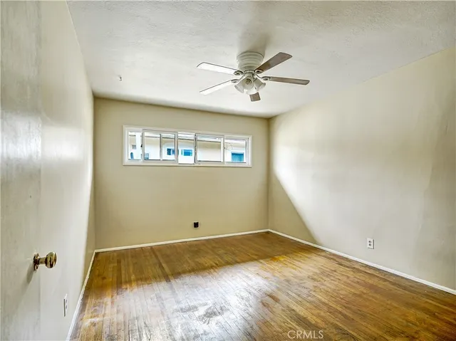 a view of a room with wooden floor and fan