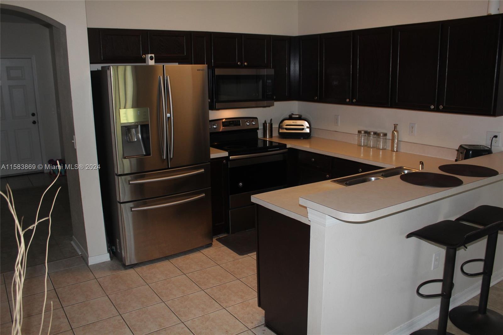1563 Blue Magnolia Road Brandon, FL 33510 - Photo 8 of 19 a kitchen with a refrigerator and a stove top oven