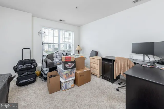 a view of a workspace with furniture and a window