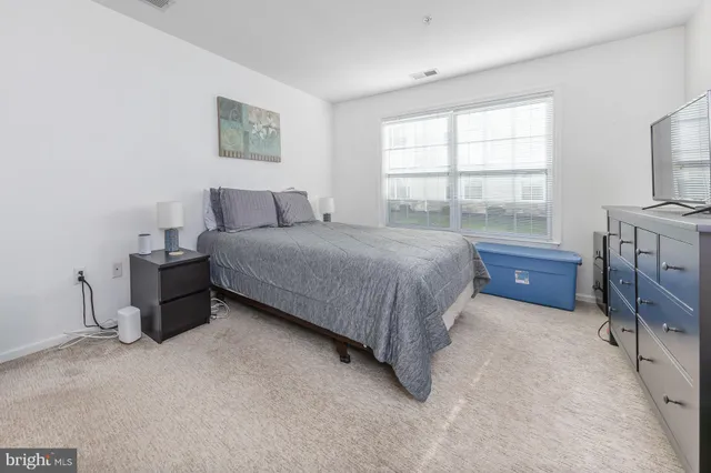 a bedroom with a bed dresser and a window