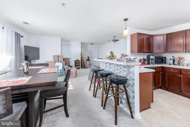 a kitchen with a table chairs microwave and cabinets