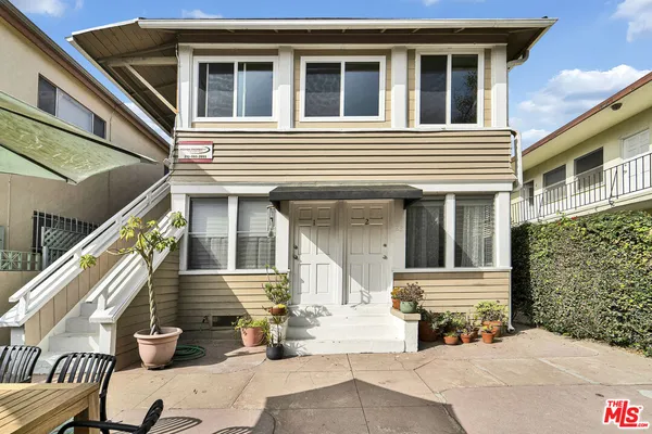 a view of a house with a patio and wooden fence