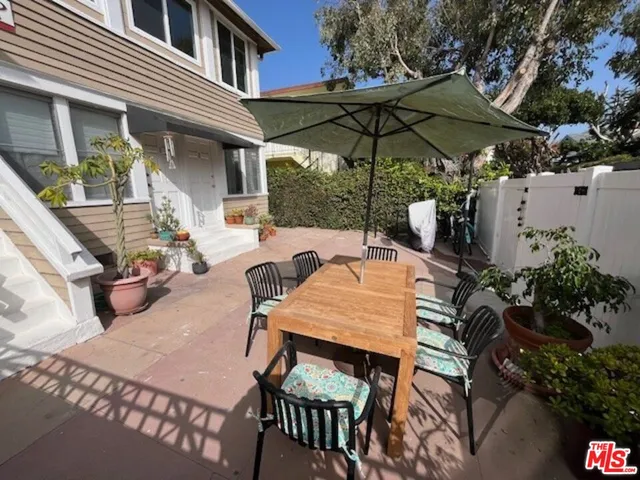 a view of a patio with table and chairs under an umbrella