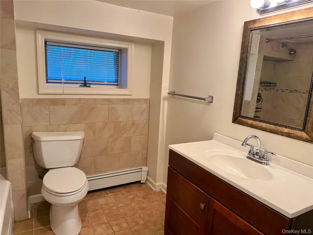 a bathroom with a toilet a sink and mirror