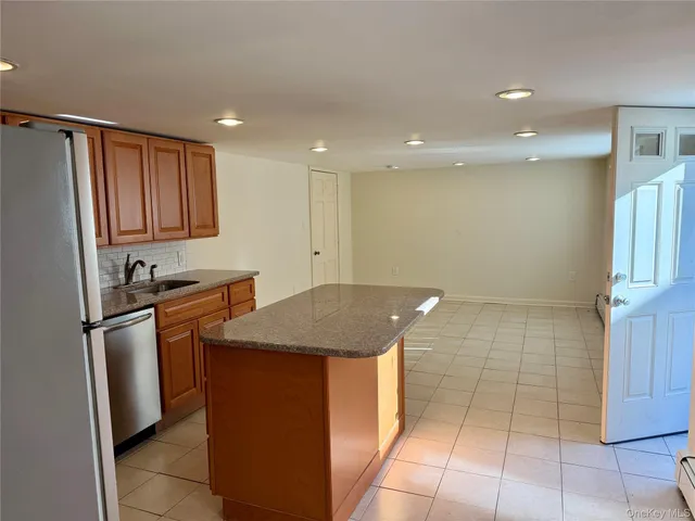 a kitchen with stainless steel appliances granite countertop a sink and a refrigerator