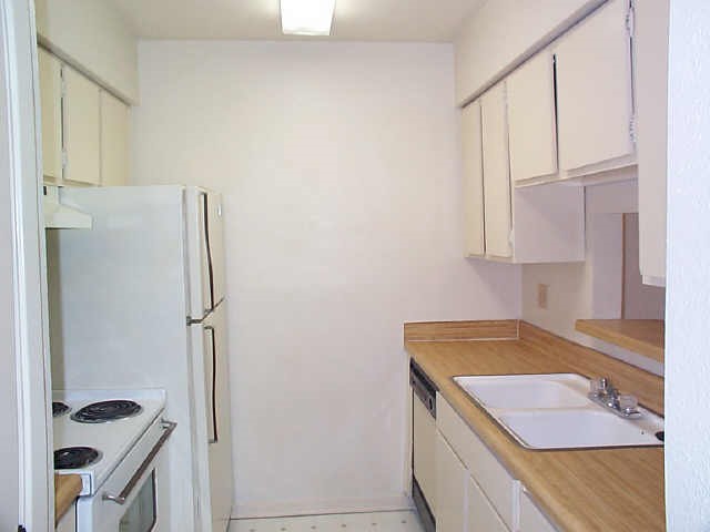 9101 Country Creek Street, Unit 403 Houston, TX 77074 - Photo 10 of 11 a bathroom with a granite countertop sink and a refrigerator