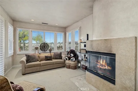 a living room with furniture a fireplace and a large window