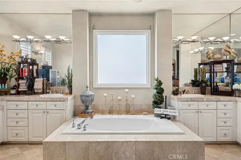 a spacious bathroom with a tub sink and a mirror