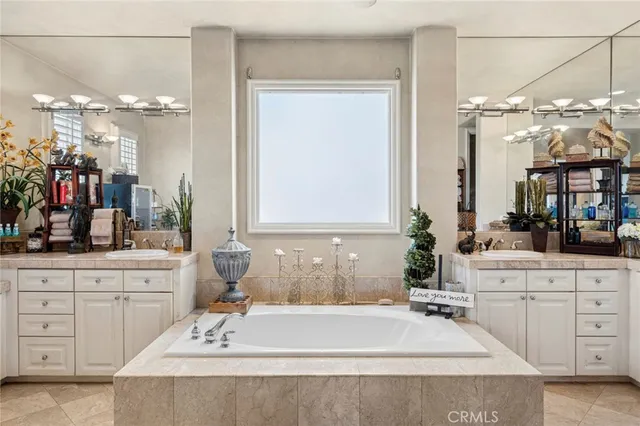 a spacious bathroom with a tub sink and a mirror