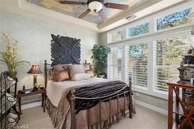 a bedroom with a bed and a large window with the garden view