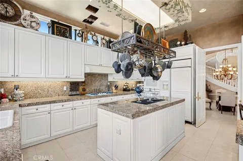 a kitchen with white cabinets and sink