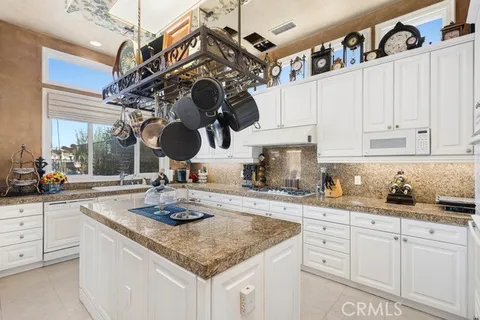 a kitchen with stainless steel appliances granite countertop a sink a stove and cabinets