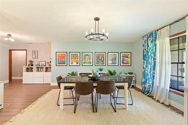 a dining room with furniture a chandelier and wooden floor