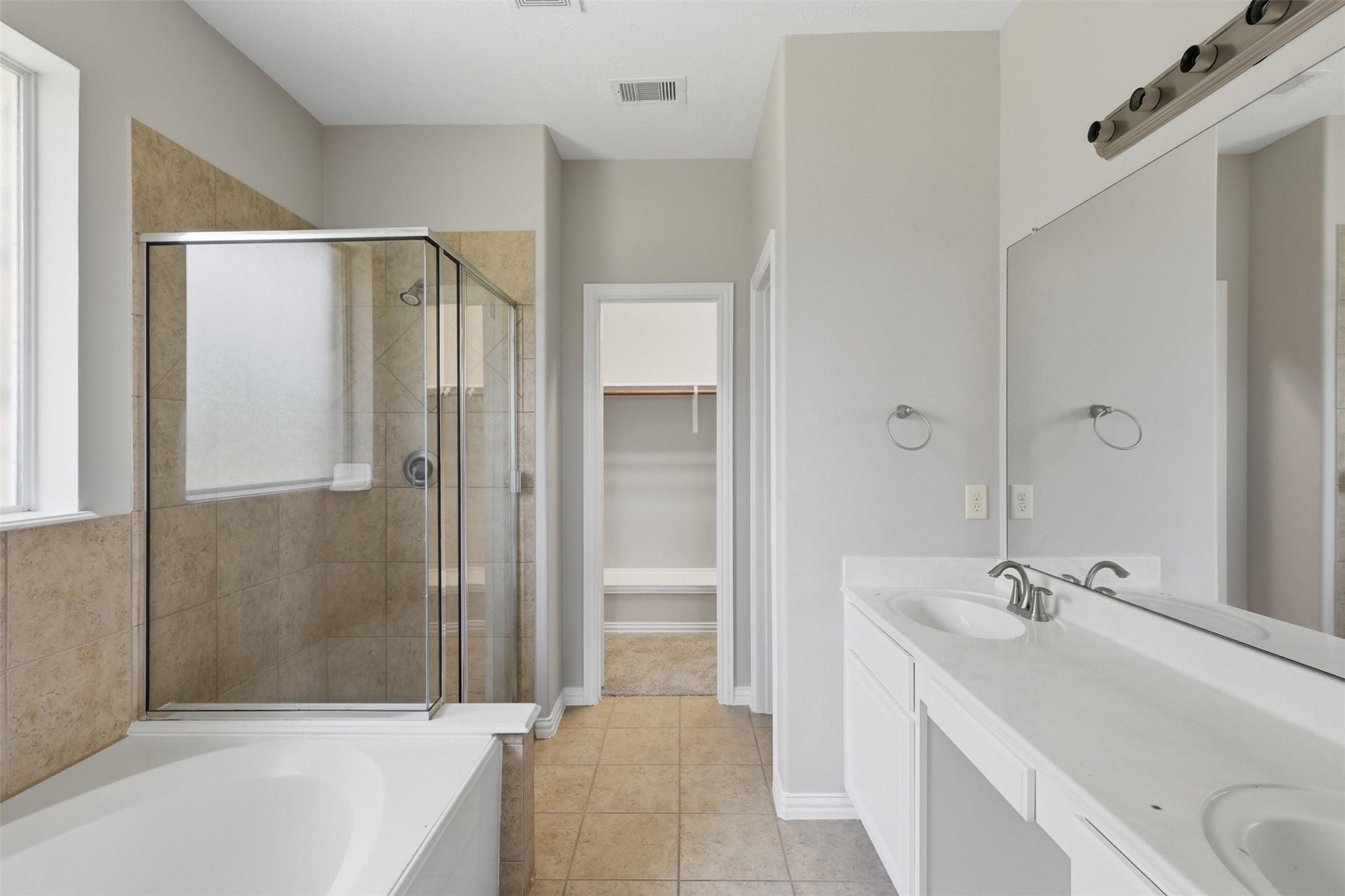 25926 Morgan Springs Spring, TX 77373 - Photo 21 of 49 The spa-inspired primary bath features dual vanities, a relaxing deep soaking tub, separate glass-enclosed shower, and abundant natural light, creating the perfect space to begin and end each day. New light fixtures coming!