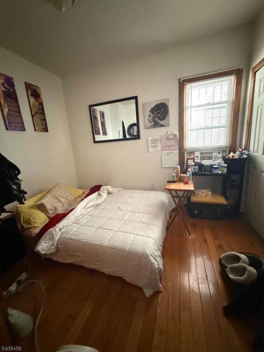 744 Trumbull Street Elizabeth, NJ 07201 - Photo 11 of 13 a bedroom with a bed and wooden floor