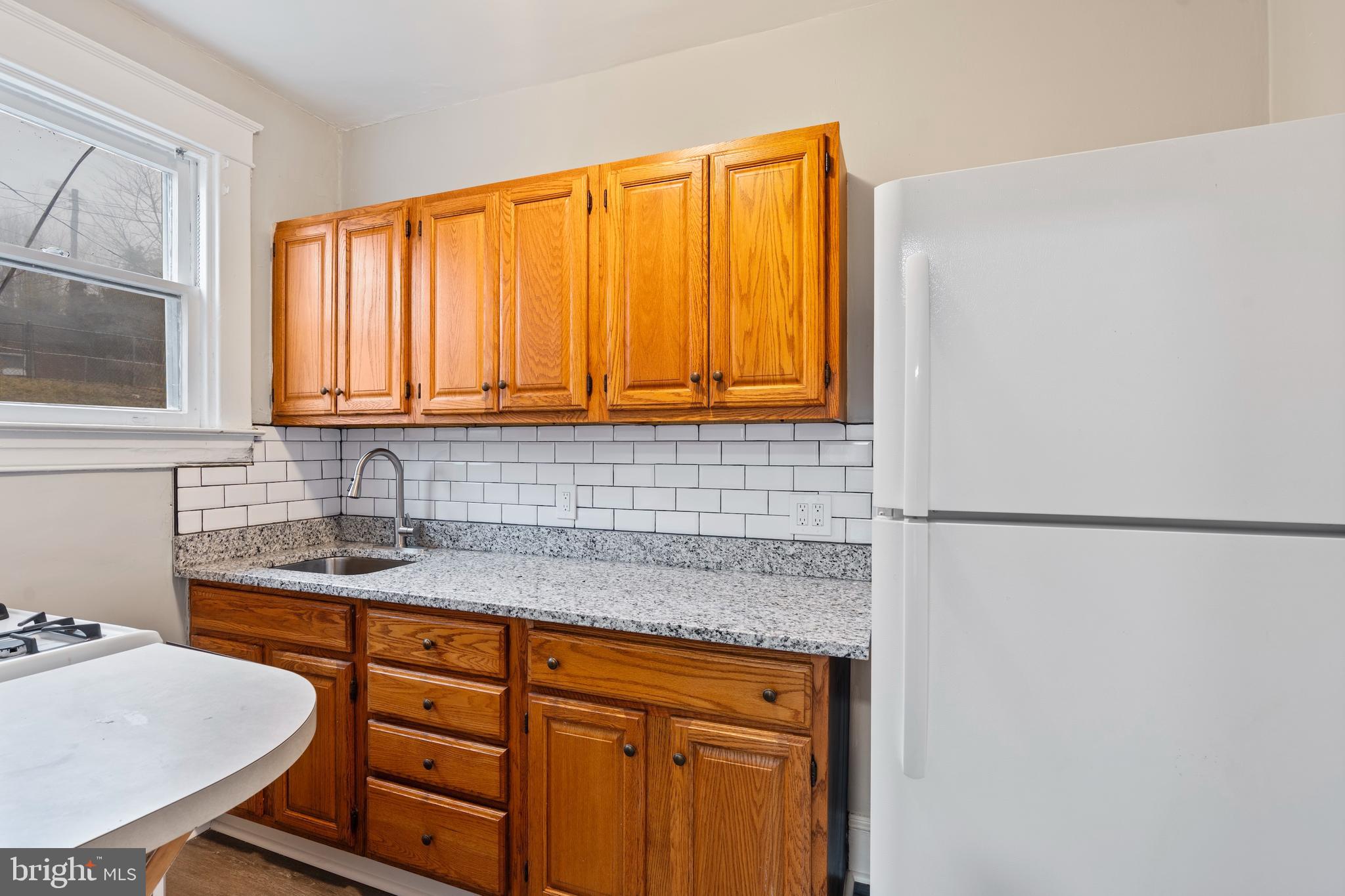 639 Plymouth Road Baltimore, MD 21229 - Photo 7 of 16 a kitchen with stainless steel appliances granite countertop a sink and a window