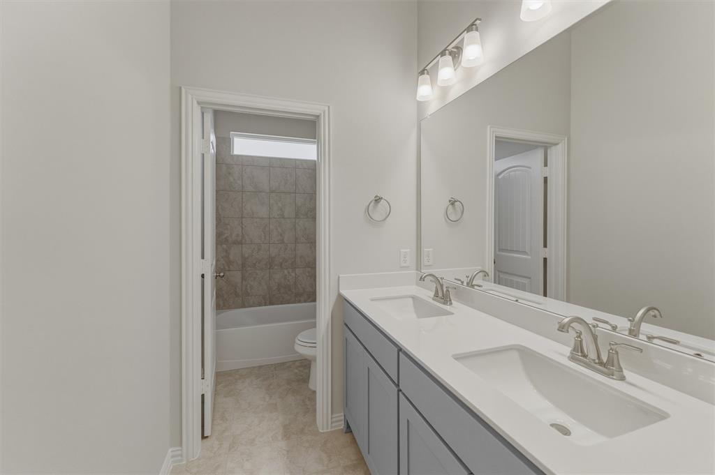 114 Hillview Trail Decatur, TX 76234 - Photo 20 of 27 Double vanity with integrated sinks, brushed nickel fixtures, and light gray cabinetry